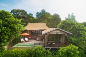ein Haus mit einer Terrasse mit Stühlen und einem Pool in der Unterkunft Serendipity Beach Resort Koh Lipe in Ko Lipe
