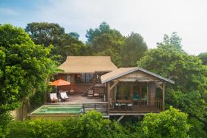 a house with a deck with chairs and a pool at Serendipity Beach Resort Koh Lipe in Ko Lipe