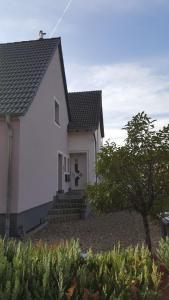 a white house with a cross on the front of it at Ferienwohnung Blütenstadt in Leichlingen