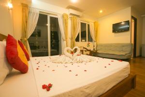 dos cisnes están sentados en una cama en un dormitorio en Golden Sea Hotel, en Nha Trang