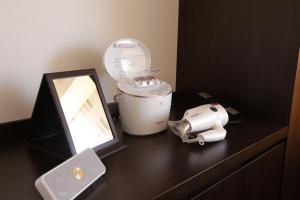 einen Waschtisch mit einem Spiegel, einem Haartrockner und einem Mixer in der Unterkunft Hotel Forza Nagasaki in Nagasaki