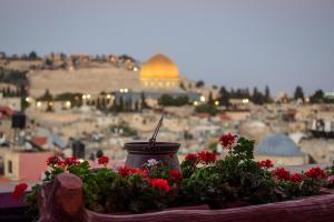 een uitzicht op de stad Jeruzalem met rode bloemen bij Hashimi Hotel in Jeruzalem