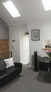 a living room with a black couch and a table at The Old Butchers in Northampton