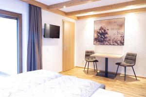 1 dormitorio con 1 cama, escritorio y 2 sillas en Haus Steinbock en Neustift im Stubaital