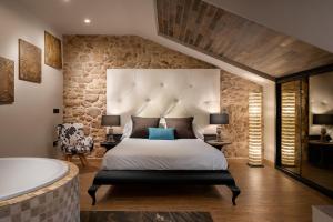 a bedroom with a large bed and a bath tub at SUITE 1907 AVILES in Avilés
