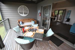 a patio with a table and chairs on a deck at Points South By The Sea in Apollo Bay