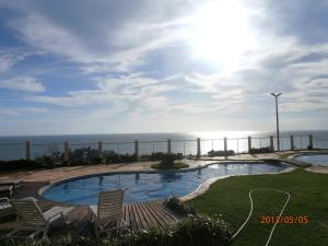 卡诺格布拉达卡诺阿魁布拉达公寓的带椅子的游泳池和背景中的海洋