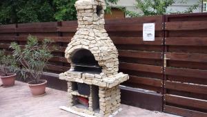 a stone pizza oven sitting next to a fence at Smeraldo Villa in Siófok