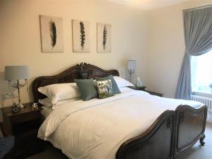 リンカーンにあるLittle Redlands B&Bのベッドルーム1室(大型ベッド1台、白いシーツ、枕付)
