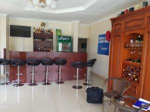 un bar con taburetes negros en una habitación en Top Lodge in Blantyre en Blantyre