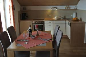una cocina con una mesa con copas de vino. en Ferienwohnung Schlossberg en Hopferau