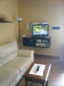 sala de estar con sofá y TV en Casa Agostini, en Lari