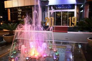a fountain with pink lights in front of a building at Grand Hotel Europa in Shkodër