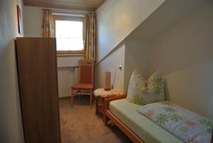 ホプフェラウにあるFerienwohnung Schlossbergのベッドと窓が備わる小さな客室です。