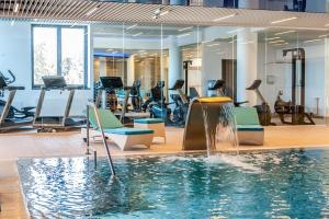 a gym with a swimming pool and exercise equipment at Apartament lux Poiana Brasov B23 in Poiana Brasov