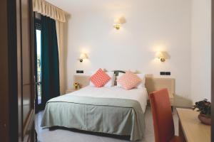 - une chambre dotée d'un lit avec des oreillers roses dans l'établissement Hotel Bixio, à Lido di Camaiore