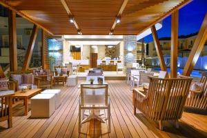 a deck on a cruise ship with tables and chairs at Lobelia Luxury Suites in Chrysi Ammoudia