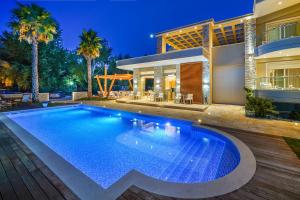una piscina di fronte a una casa di Lobelia Luxury Suites a Chrisi Ammoudia