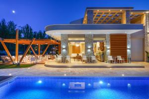 una casa con una piscina di fronte di Lobelia Luxury Suites a Chrisi Ammoudia