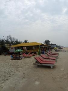 a row of lounge chairs and umbrellas on a beach at Casberly Apartment in Varca
