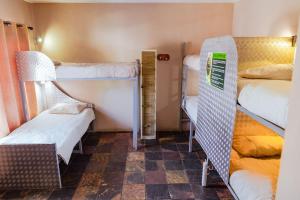 Chameleon Backpackers & Guesthouse tesisinde bir odada yatak veya yataklar