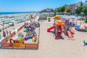 リミニにあるResidenza Aurora del Mareの砂浜の遊具がたくさんあるビーチ