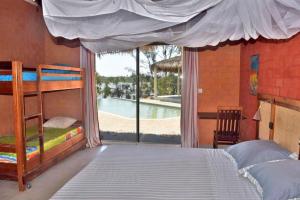 a bedroom with a bunk bed and a view of a pool at Antsanitia - Domaine du Mandravasarotra in Antsianitia