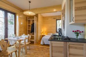 eine Küche und ein Esszimmer mit einem Tisch und einem Bett in der Unterkunft Pokoje i Apartamenty Centrum - Willa Bajeczka in Zakopane