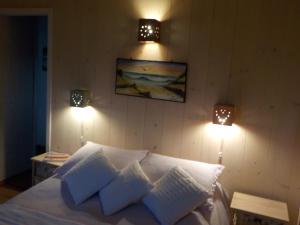 ein Schlafzimmer mit einem Bett mit zwei Lichtern an der Wand in der Unterkunft LAS ESCAMADAS ecocottage in Punta Del Diablo