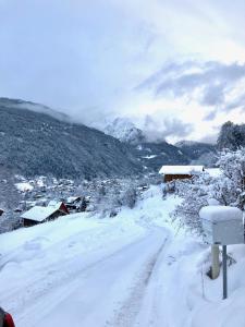 a snow covered road with a village in the distance at Chalet Kizuna in Saint-Gervais-les-Bains