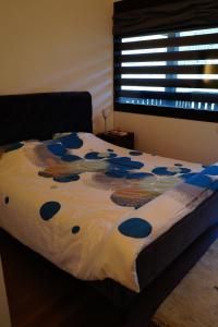 a bed with a blue and white comforter and a window at Chalet Kizuna in Saint-Gervais-les-Bains +10 photos