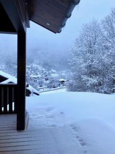 a snow covered porch with a view of a town at Chalet Kizuna in Saint-Gervais-les-Bains