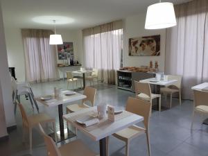 a dining room with white tables and chairs at Dodo House in Nocera Inferiore