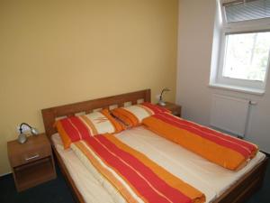 a bed with colorful blankets on it in a bedroom at Lipovka penzion in Hodonín