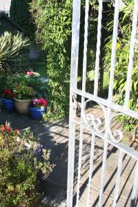 a white gate in a garden with potted plants at TOWNHOUSE ROOMS in Truro