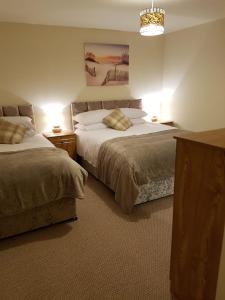 a bedroom with two beds and two lights on at LegenDerry B&B in Derry Londonderry