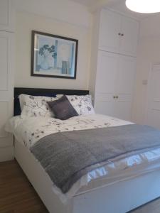 a bedroom with a large bed with white cabinets at Garden Flat, Ealing in Ealing
