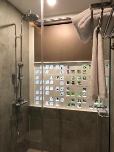a bathroom with a shower with a glass shower stall at La An Homestay in Hoi An