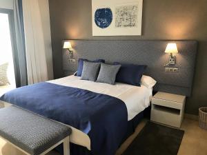 sypialnia z dużym łóżkiem z niebieską i białą pościelą w obiekcie Coral Beach Aparthotel w Marbelli