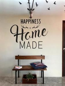 Una pared con una señal que dice que la felicidad está hecha en casa en Stella Moonlight Khaoyai, en Pong Talong