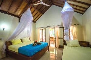 a bedroom with two beds in a room at Fantastic Cottages in Gili Meno
