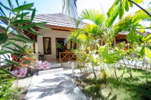 a small house with a garden in front of it at Fantastic Cottages in Gili Meno