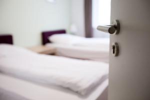 a door open to a room with white beds at Hotel City Green Berlin in Berlin