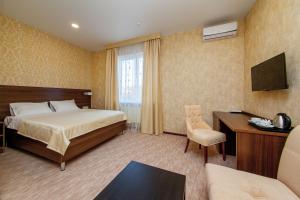 Cette chambre comprend un lit et un bureau. dans l'établissement D Hotel, à Krasnodar