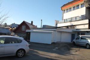 a car parked in a parking lot next to a building at Kløver Hotel in Sauda