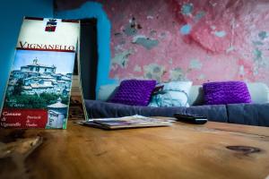 a table in a room with a couch and a banner at Giamevi House in Vignanello