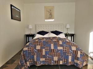 ein Schlafzimmer mit einem Bett mit einer Decke darauf in der Unterkunft Fossatún Country Hotel in Fossatún