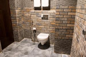 a bathroom with a toilet in a brick wall at Valley View Residency in Darjeeling