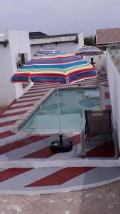 uma piscina com um guarda-sol e uma mesa em Fourties Guest House em Phalaborwa