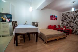 jadalnia ze stołem i czerwoną kanapą w obiekcie Apartment Šamorín w mieście Šamorín
